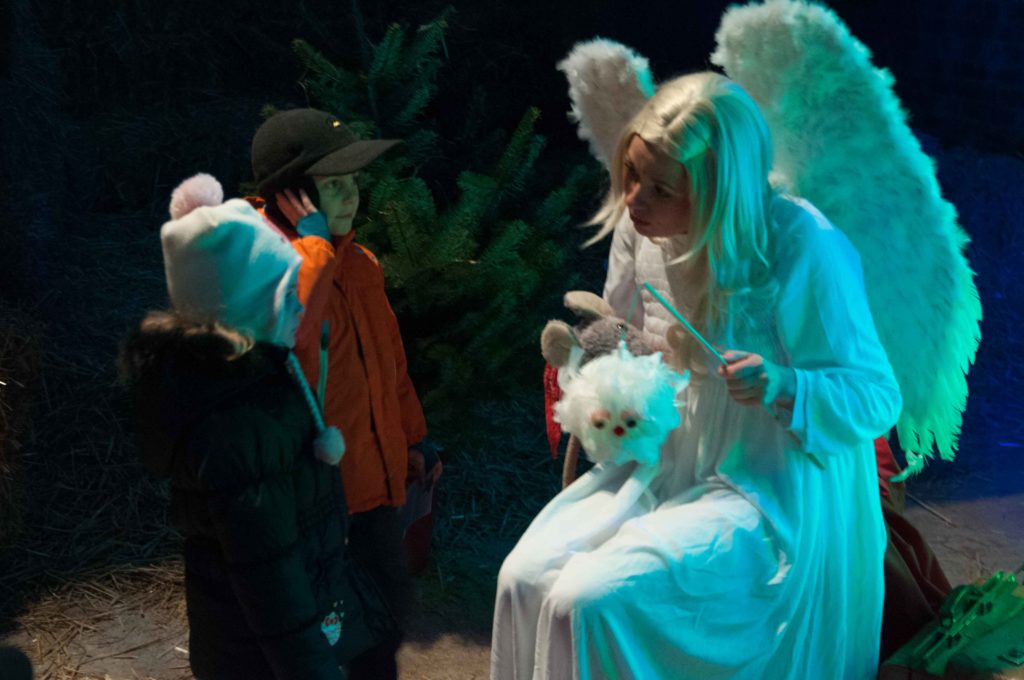 Engel Marie aus dem Theaterstück Warten auf das Christkind spricht mit Kindern